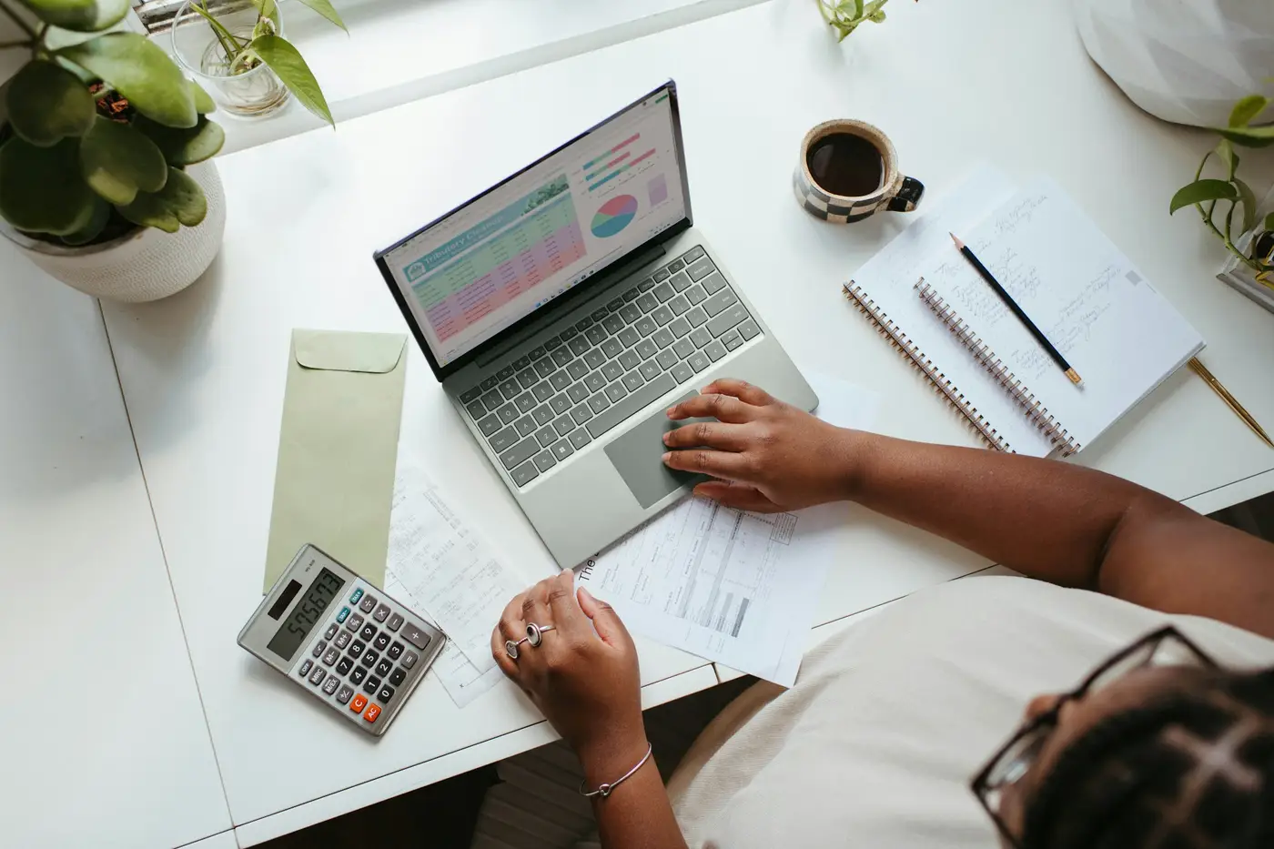Vue de dessus d'un bureau avec ordinateur, calculatrice et documents