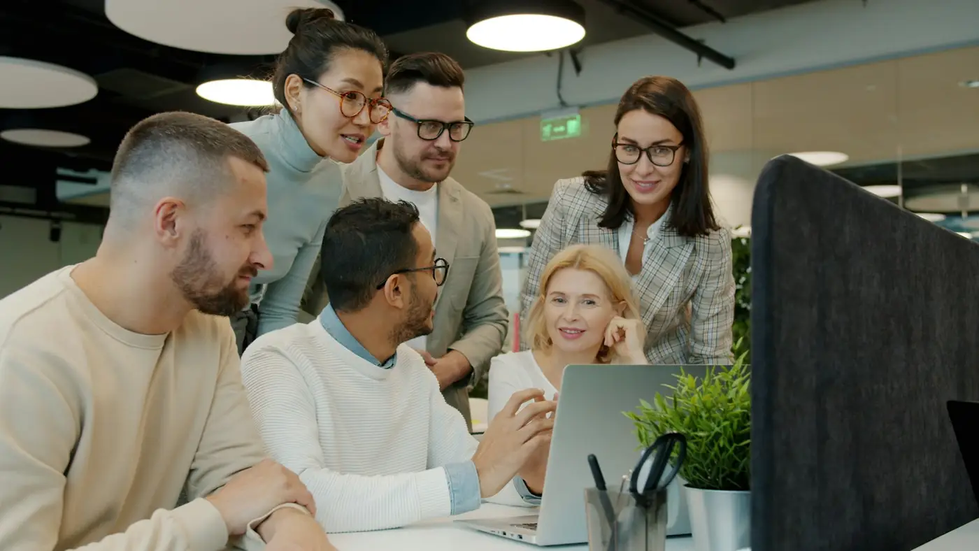 Professionnels réunis autour d'un ordinateur pour un point de travail